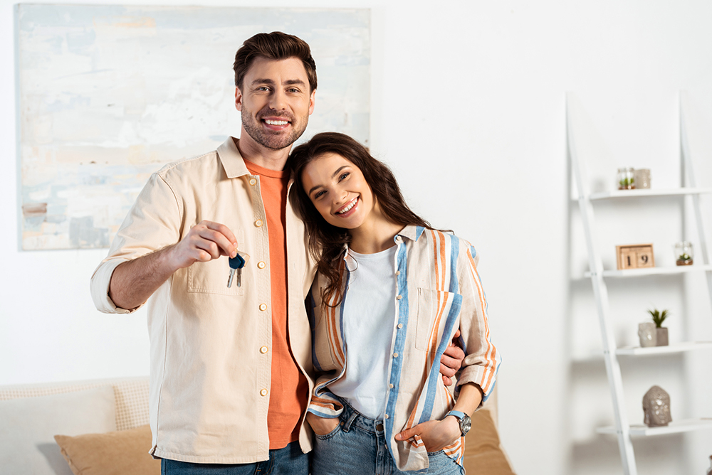 Couple holding the keys to their new house after getting a home inspection